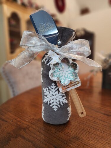 Festive holiday wine bottle with wooden spoon and holiday cookie cutter, perfect for winter decor or handmade Christmas gifts.